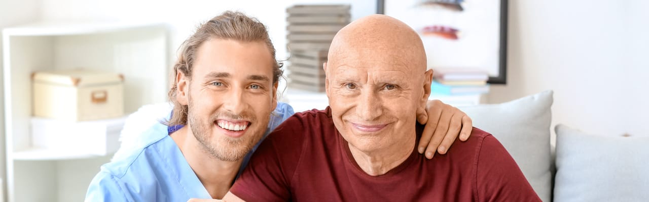 Caregiver and resident smiling together in a bright interior