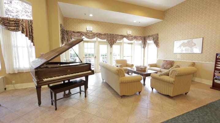 Bright common area with seating and a piano