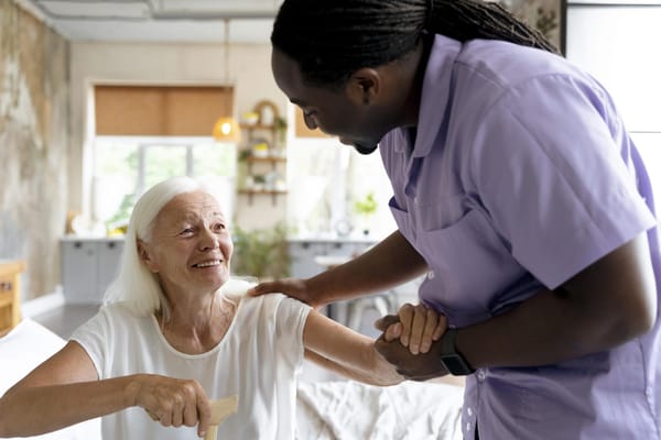 Staff assisting a resident in a well-lit room