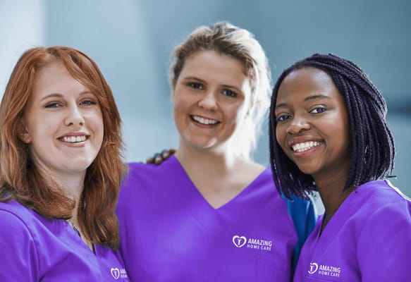 Three smiling staff members wearing purple uniforms