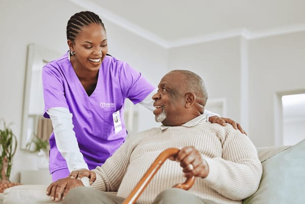 A caregiver interacting with a smiling senior resident indoors