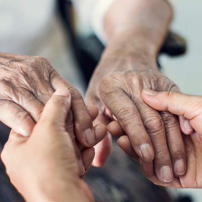 Close-up of elderly hands being held
