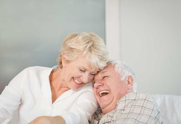 Two smiling seniors sharing a joyful moment