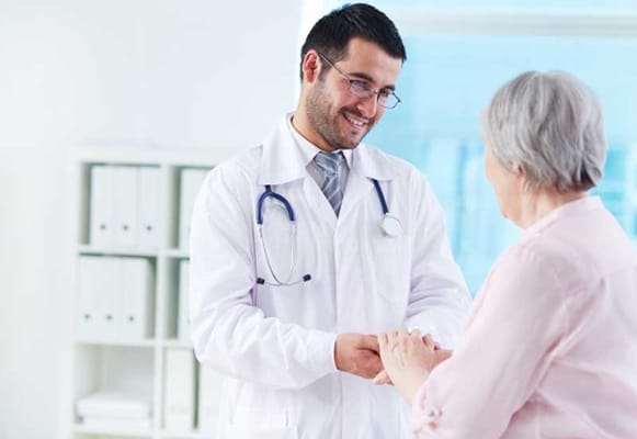 A healthcare professional interacting with an elderly woman in a bright room