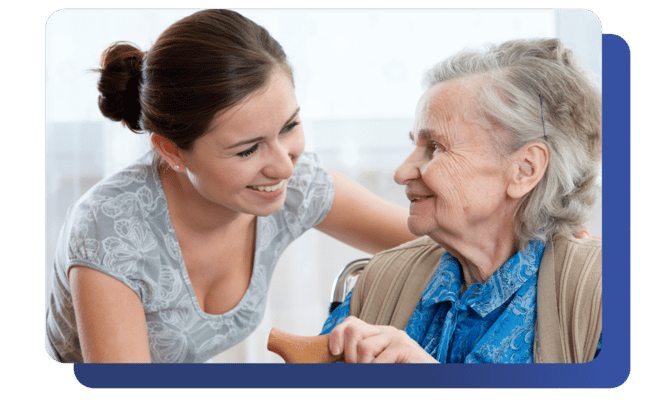 Caregiver smiling and engaging with an elderly resident
