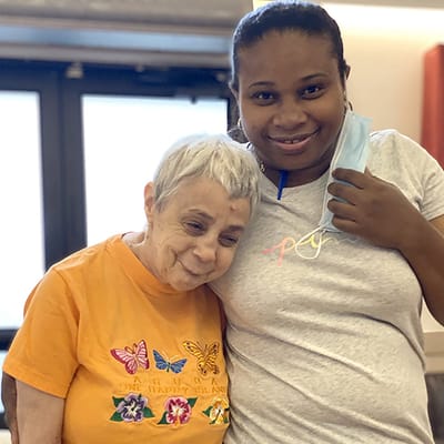 Staff member and resident smiling together in a common area