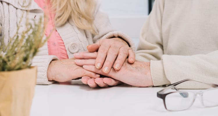 Two hands holding gently on a table