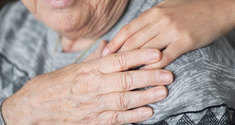 Close-up of an elderly person's hand being held