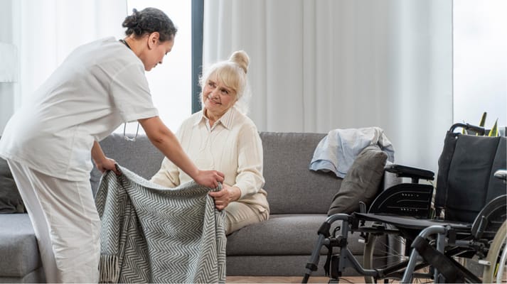 Caregiver assisting a resident in a cozy living area