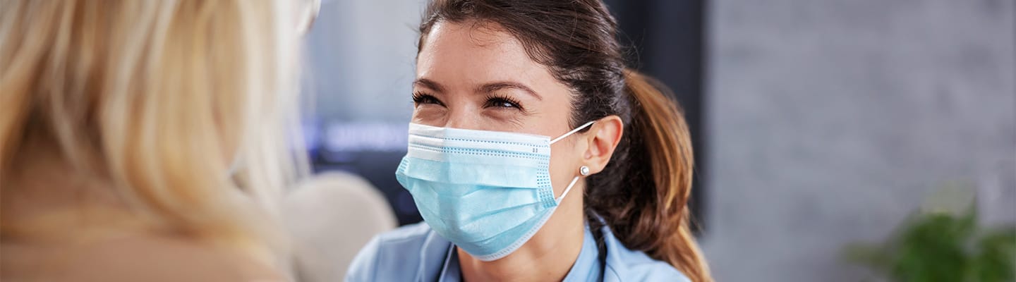 Healthcare worker smiling while assisting a resident