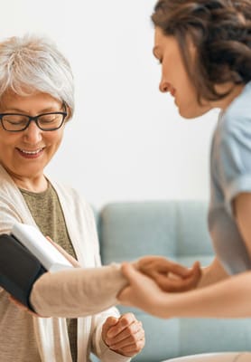Healthcare worker assisting a senior with blood pressure check