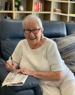 Resident enjoying a crossword puzzle in a lounge chair