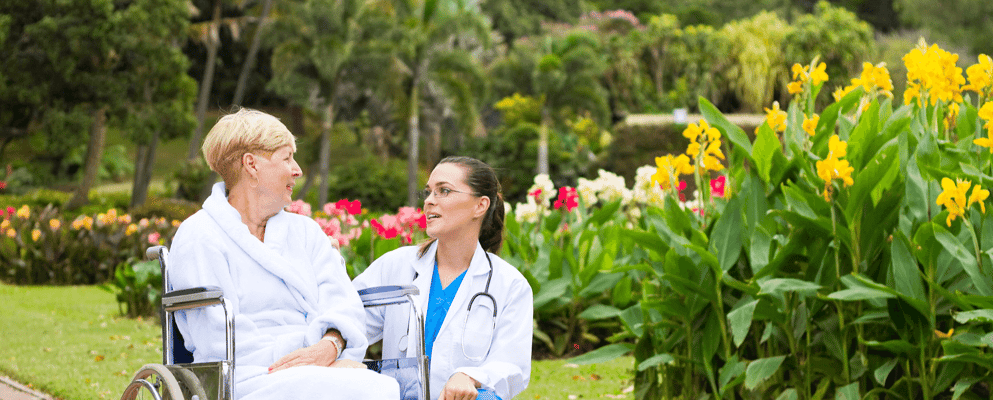 A caregiver and resident in a garden setting