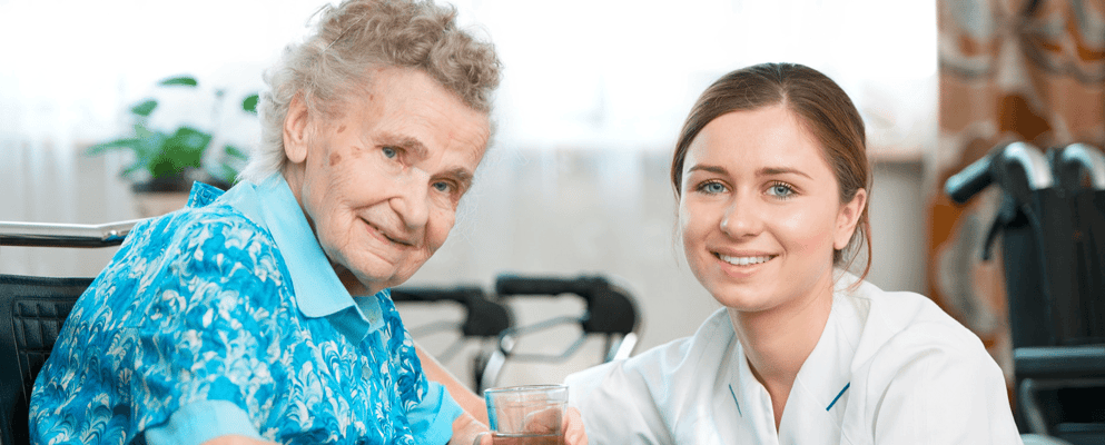 Caregiver interacting with a senior resident in a bright room