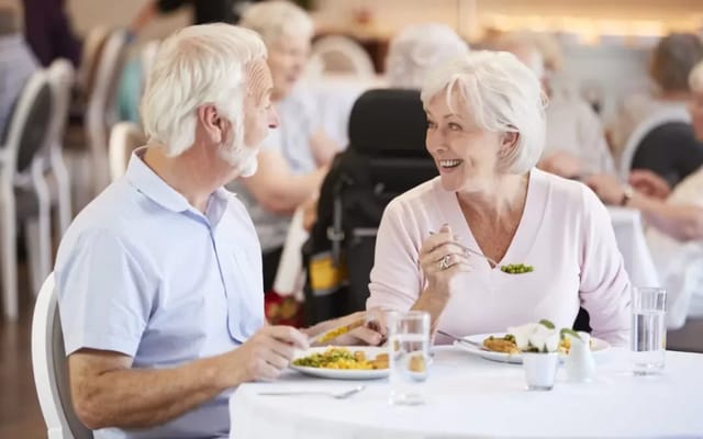 Two residents enjoying a meal in the dining area