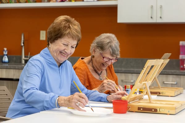 Residents enjoying a painting activity in a bright room