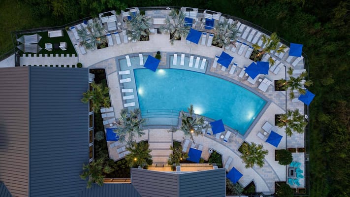 Aerial view of a pool area with lounge chairs and umbrellas