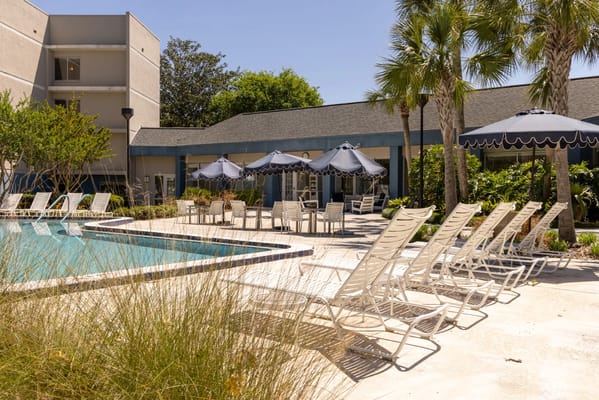 Sunny outdoor pool area with lounge chairs