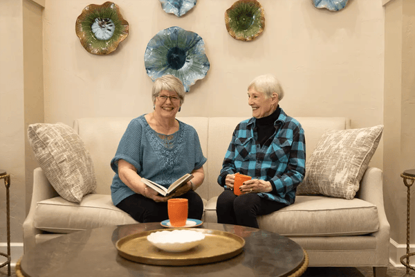 Two residents enjoying a conversation in a cozy common area