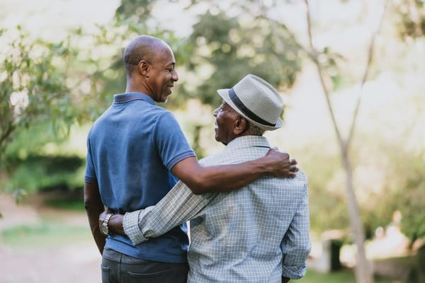 Two men enjoying a moment outdoors in a garden