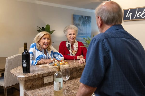 Residents enjoying wine and conversation at a bar