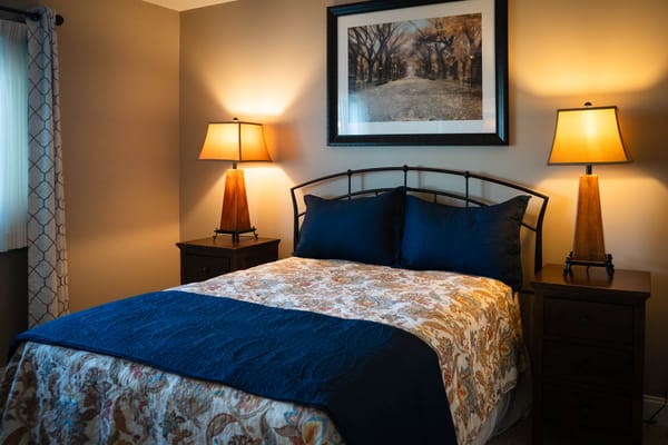 Cozy bedroom with a floral patterned blanket and warm lighting
