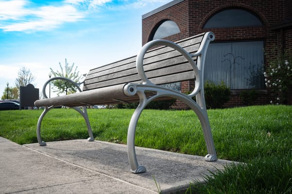 A park bench in front of a well-maintained facility
