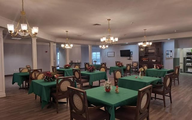 Dining area with green tables and floral centerpieces