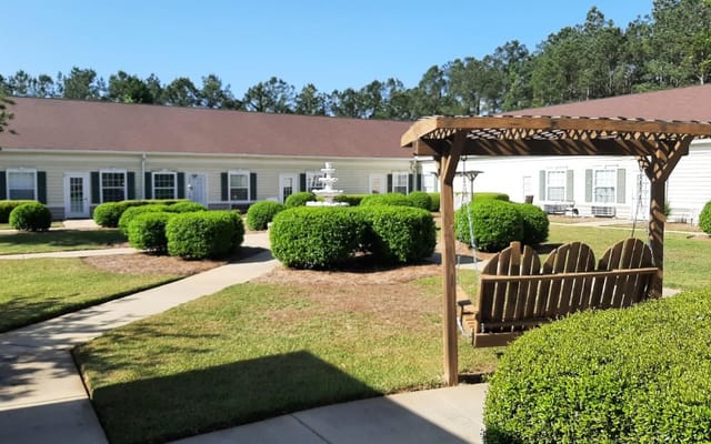 Outdoor garden area with swing and neatly trimmed bushes