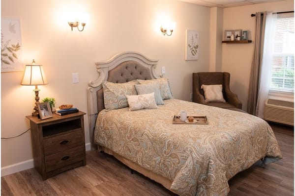 Well-decorated bedroom with a bed, nightstand, and armchair.