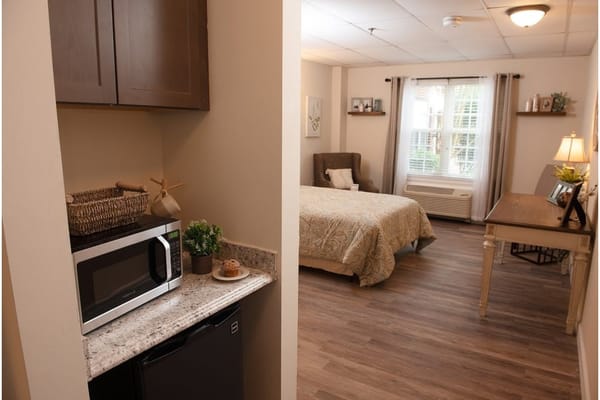 Interior view of a cozy senior living room featuring a kitchenette
