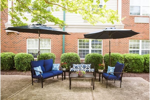 Cozy outdoor seating with umbrellas at Viva Senior Living