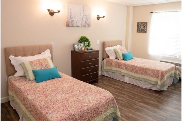 Bright and inviting bedroom with two beds and wooden furniture.