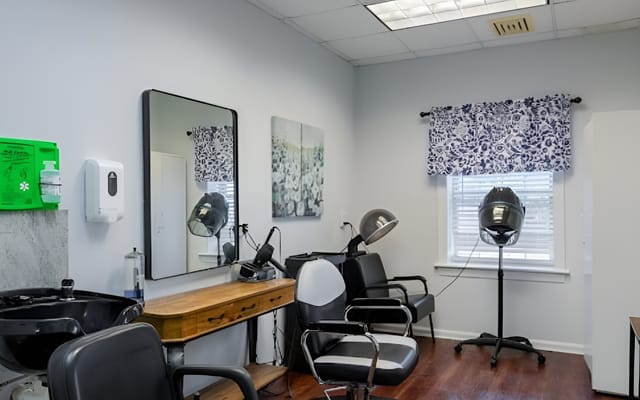Well-furnished hair salon area with styling chairs and mirrors
