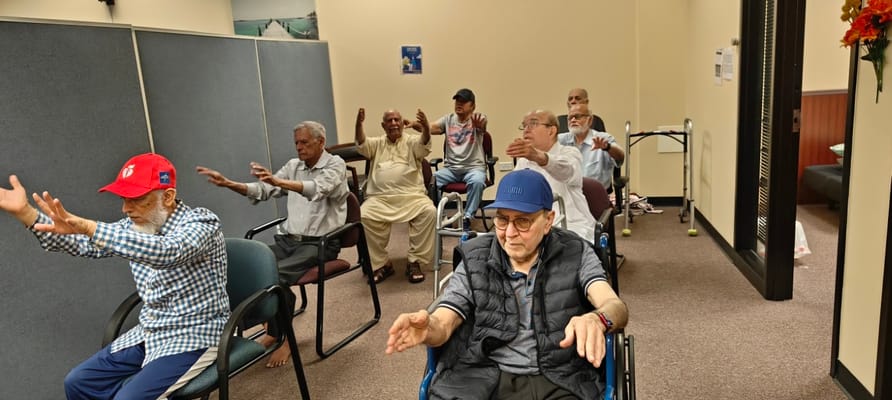 Group of senior residents participating in a seated exercise class.