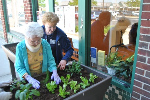 Residents and staff gardening outside the center