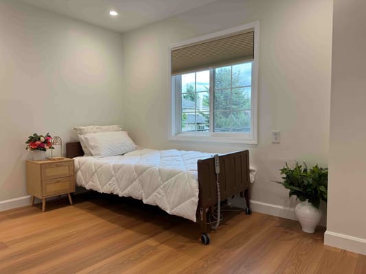 Bright bedroom with a hospital bed and side table