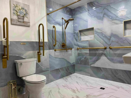 Modern accessible bathroom featuring grab bars and elegant tile design.