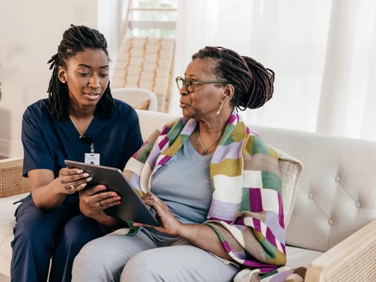 Caregiver assisting a resident with a tablet