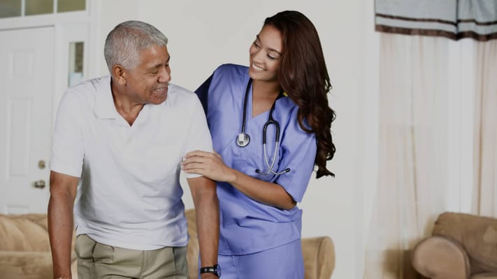 A staff member assisting a senior resident indoors
