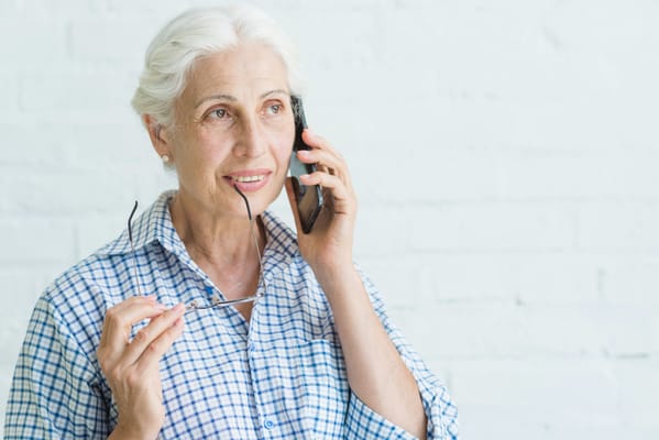 Senior woman on the phone, holding glasses