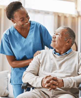 Caregiver smiling while assisting a resident indoors