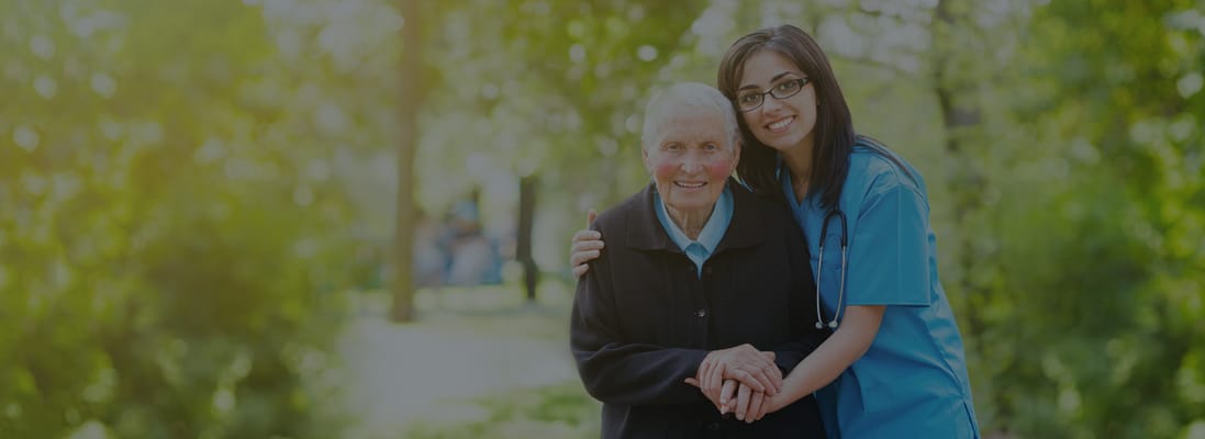 Caregiver embracing a resident in a garden
