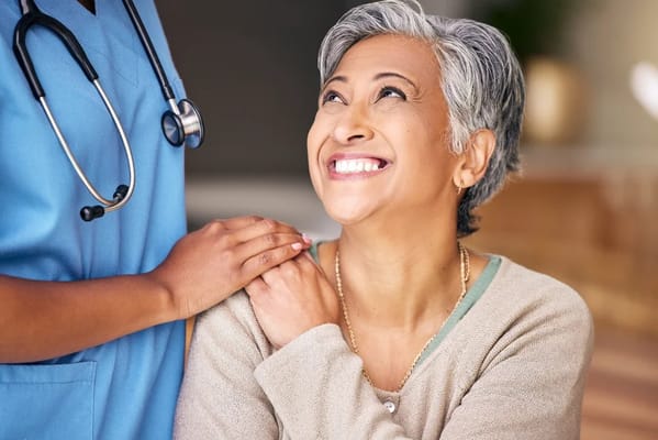 Resident smiling with a caregiver in an indoor setting