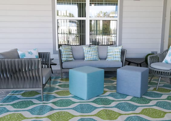 Outdoor lounge area with seating and decorative rug
