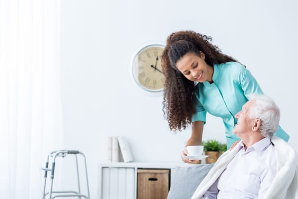 A caregiver attending to a resident in a cozy indoor setting