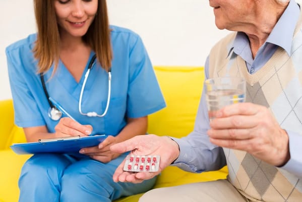 Healthcare professional assisting a senior with medication