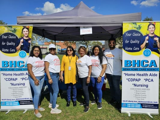 Staff members at a community event with a tent