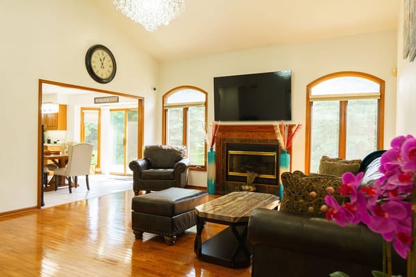 Cozy living room featuring a fireplace, comfortable seating, and large windows.