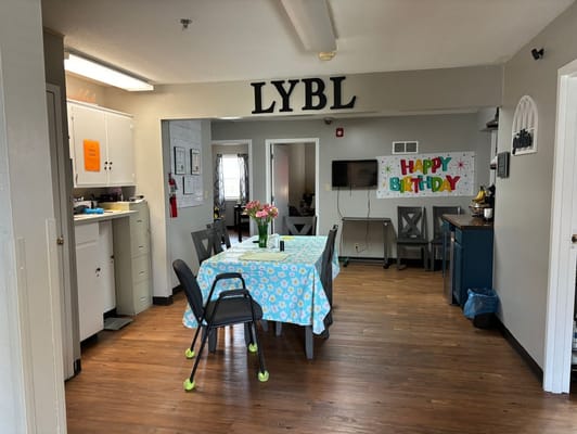 Brightly decorated community room with a birthday banner